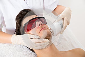 Beautician Giving Laser Epilation Treatment To Man Face