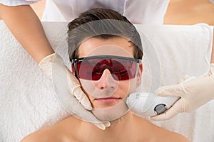 Beautician Giving Laser Epilation Treatment To Man Face photo