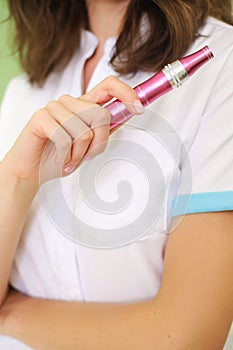 The beautician holds in his hands a dermapen, a tool for mesotherapy and cell regeneration. photo