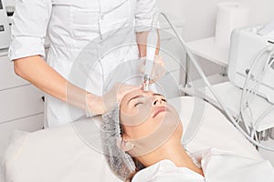 Beautician makes aqua exfoliation for rejuvenation woman face skincare, procedure in beauty salon