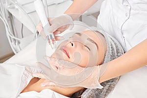 Beautician makes aqua exfoliation for rejuvenation woman face skincare, procedure in beauty salon