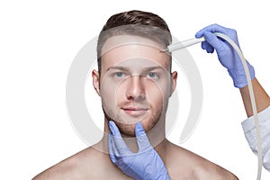 Beautician makes a man a procedure to remove acne from his face photo