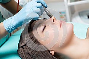 Beautician makes mechanical cleaning of face. Procedure of Microdermabrasion, diamond grinding.