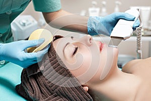 Beautician makes Ultrasonic cleaning of face. cosmetology