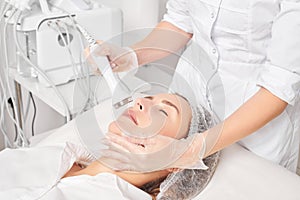 Beautician makes ultrasound skin tightening for rejuvenation woman face using phonophoresis