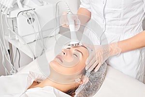 Beautician makes ultrasound skin tightening for rejuvenation woman face using phonophoresis