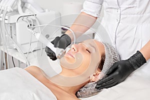 Beautician makes ultrasound skin tightening for rejuvenation woman face using phonophoresis