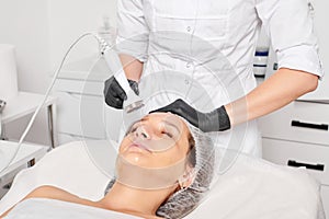 Beautician makes ultrasound skin tightening for rejuvenation woman face using phonophoresis