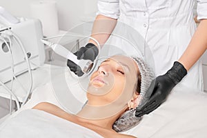 Beautician makes ultrasound skin tightening for rejuvenation woman face using phonophoresis