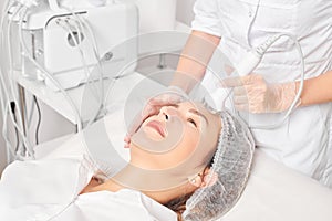 Beautician makes ultrasound skin tightening for rejuvenation woman face using phonophoresis