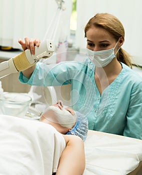 Beautician makes vaporization procedure to young woman. The cosmetic procedures for the face. Beauty treatments in the