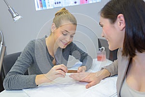 Beautician manicuring lady`s nails photo