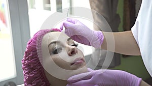 Beautician marking face for cosmetic injection in medical clinic. Woman in beauty clinic. Face care and anti aging
