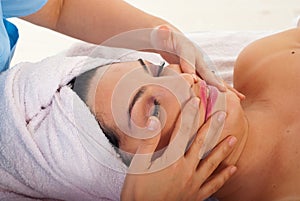 Beautician massaging woman face