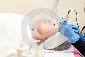 A beautician performs a rejuvenating mesotherapy procedure using dermapen. photo