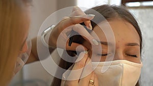 Beautician plucks extra eyebrows for young woman