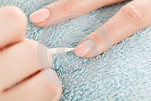 Beautician preparing nails before manicure, pushing back cuticles photo