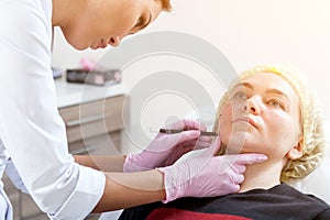 Beautician pushes a syringe to inject Botox