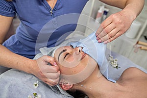 beautician removes the mask from the client in the spa