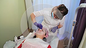 Beautician removes the mask from the woman`s face. Reddened, irritated skin after mesotherapy. Bb Glow