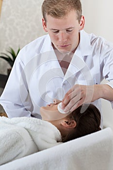 Beautician removing woman's makeup