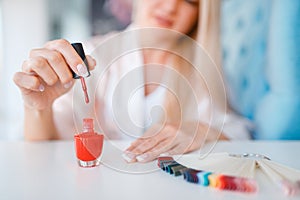 Beautician salon, manicure, woman with nail varnish