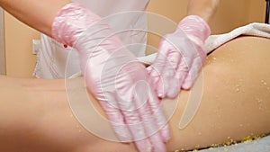 Beautician scrubbing client body in salon. Beauty treatment concept. massage treatment scrub with spa salt and essential