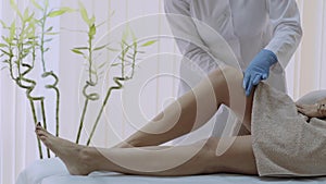 Beautician in the spa center prepare woman s legs for depilation. 4k