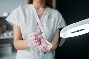 Beautician with syringe in hands, botox injection