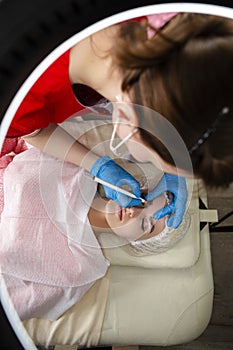Beautician Tattooing Woman`s Eyebrows Using Special Equipment During Process of Permanent Make-up