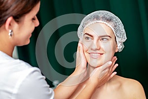 Beautician is touching face of woman