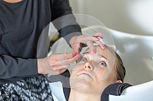 Beautician trimming a young girls eyebrows