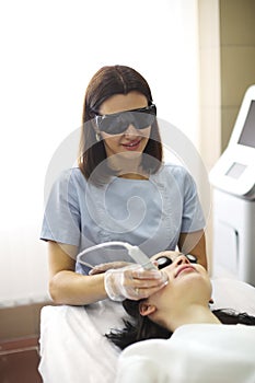 Beautician using machine for radiofrequency lifting