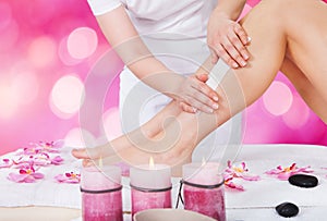Beautician Waxing Woman Leg With Wax Strip