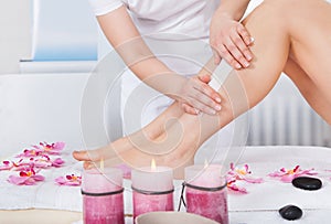 Beautician waxing woman's leg photo