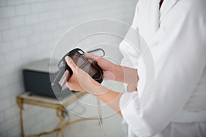 Beautician in white lab coat checking weight of young woman