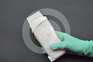 A beauticians hand with green glove holding a portable roll on d