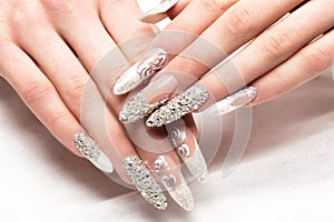 Beautifil wedding manicure for the bride in gentle tones with rhinestone. Nail Design. Close-up photo