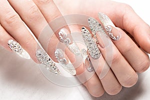 Beautifil wedding manicure for the bride in gentle tones with rhinestone. Nail Design. Close-up photo