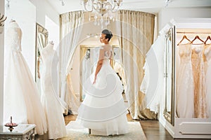 Beautifu bride choosing wedding dress in a wedding salon