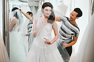 Beautifu bride choosing wedding dress in a wedding salon