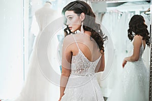 Beautifu bride choosing wedding dress in a wedding salon