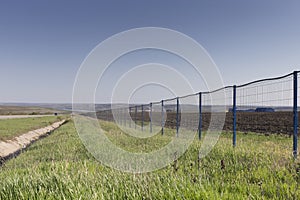 Beautifu spring landscape and a modern metal fence