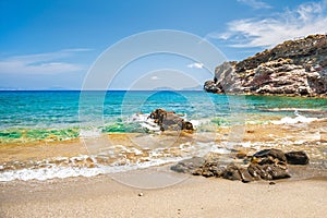 Beautifu tropical beach with clear turquoise water and rocks.