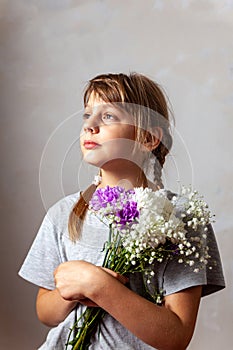 Beautiful 10-year-old girl with  bouquet of flowers in her hands