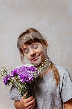 Beautiful 10-year-old girl with  bouquet of flowers in her hands