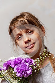 Beautiful 10-year-old girl with  bouquet of flowers in her hands