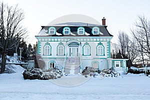 Beautiful 19th century white house with Mansard metal roof seen during an early morning winter