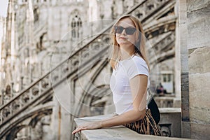 Beautiful 30s woman in sunglasses posing on Roof of Milan Cathedral Duomo di Milano, Italy. Traveling Europe in summer