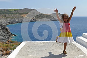 Beautiful 4 year old girl dancing with the beautiful sea background